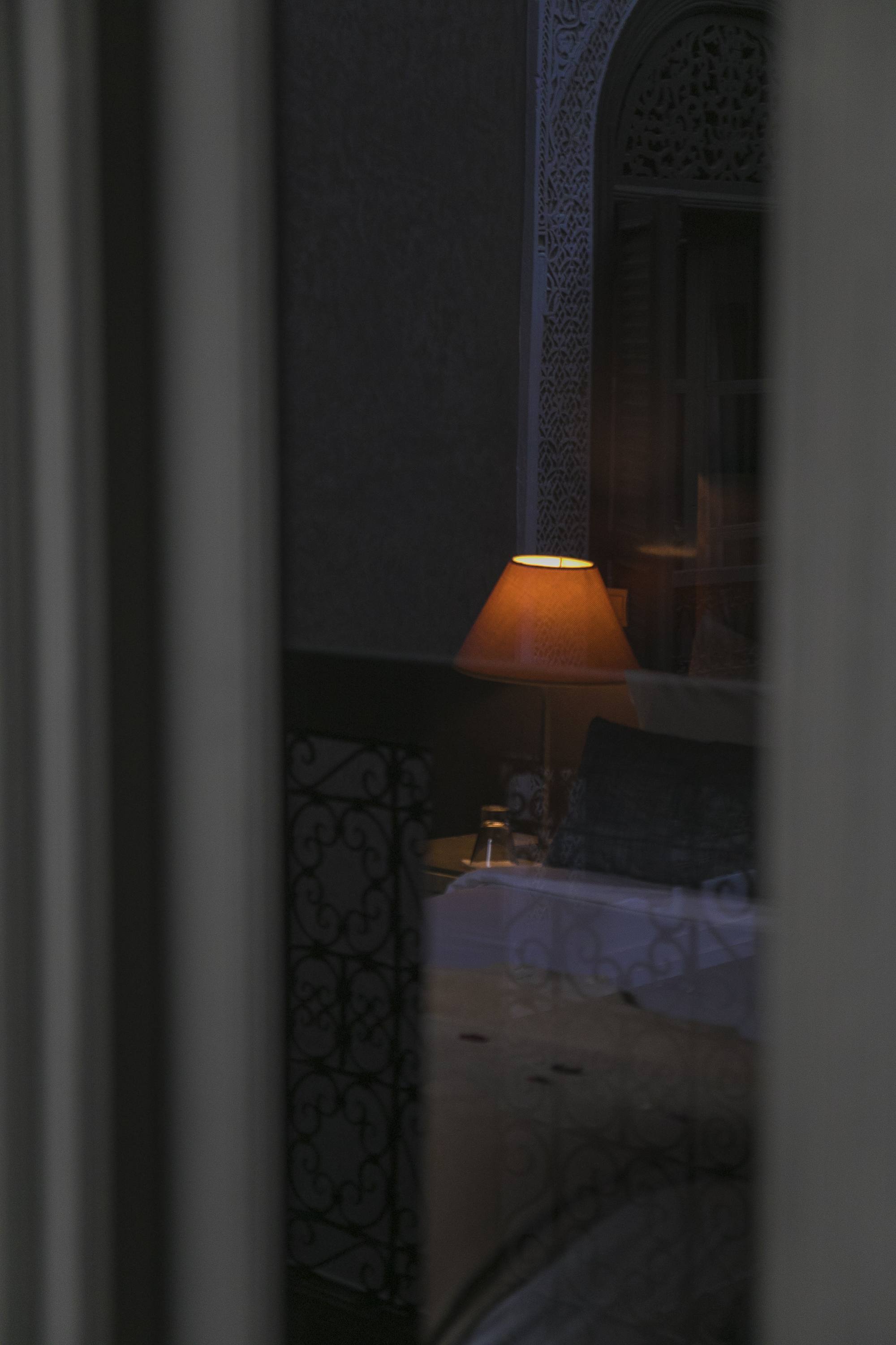 Une lampe veille derrière le moucharabieh, à la nuit tombée