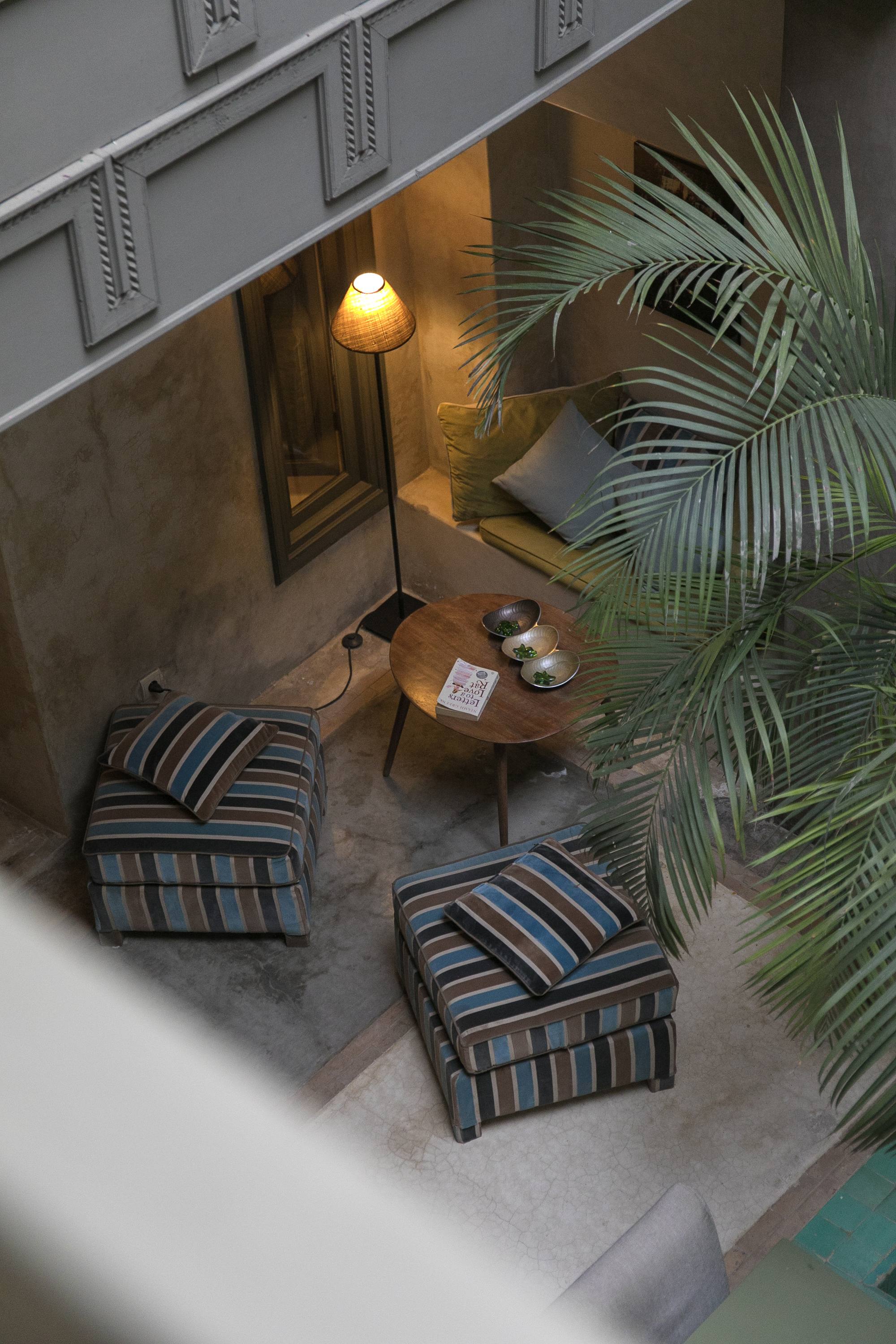 Le patio du Riad Dar One au crépuscule, une lampe allumée dans le coin salon sous la galerie