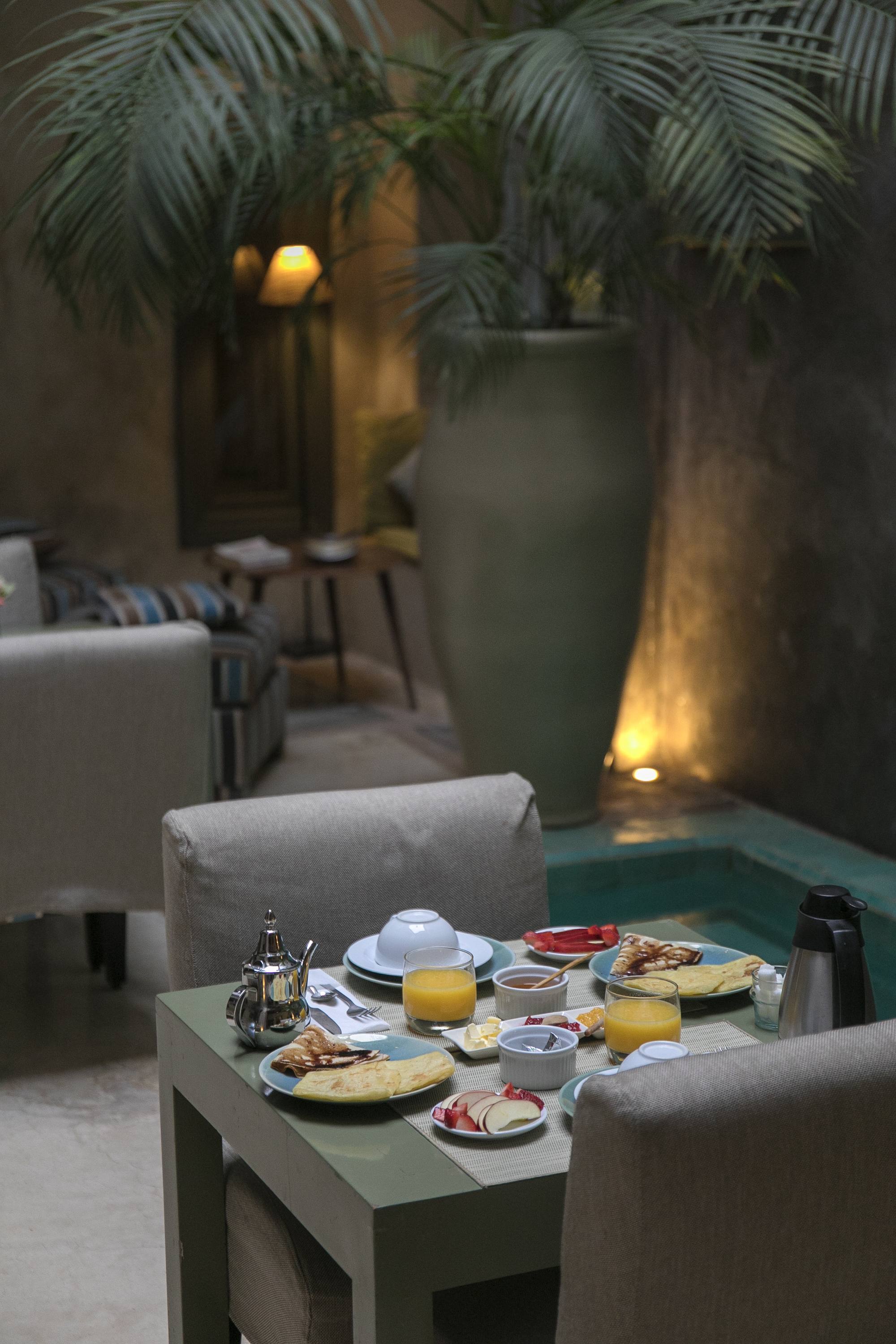 Le patio du Riad Dar One à la nuit tombée, lanternes et lampes basses sous la galerie