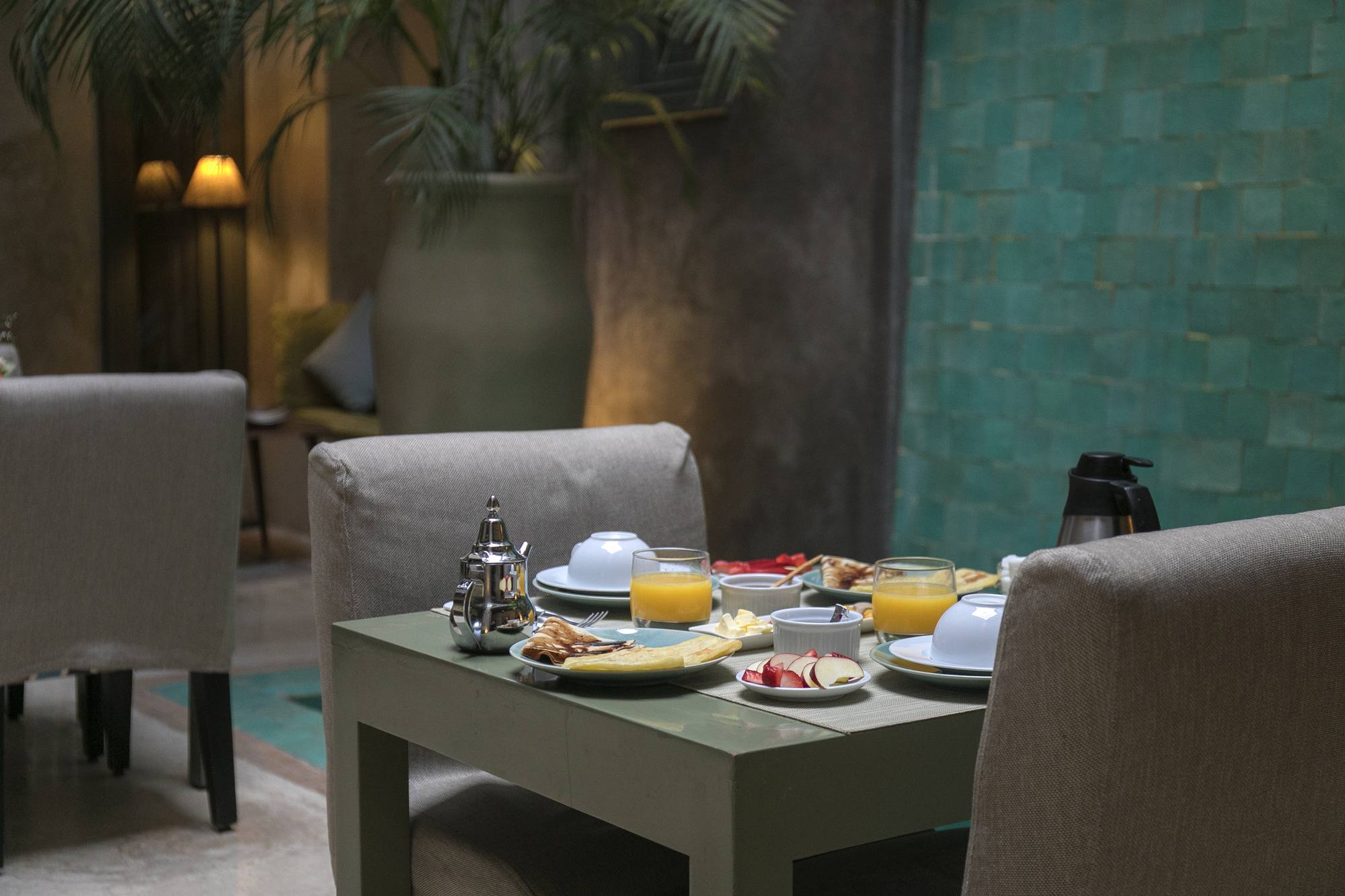 La table dressée au patio, dans la lumière chaude des lampes du soir